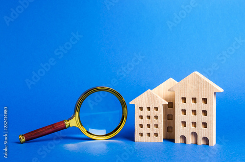 figures of house apartments buildings and magnifying glass. Home appraisal. Property valuation. Realtor services for renting and buying an apartment or house. House searching concept. Real estate photo