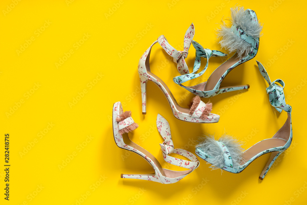 Summer women's high-heeled shoes. Flamingo hummingbirds and feathers. Yellow paper background.