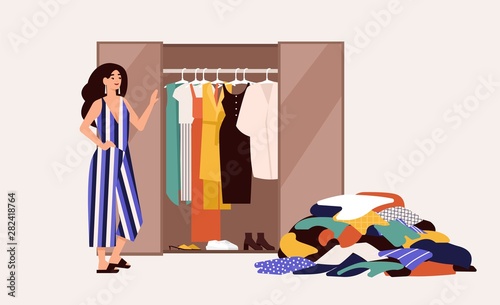 Cute girl standing in front of opened wardrobe with apparel hanging inside and pile of clothes on floor. Concept of closet declutter and organization. Flat cartoon colorful vector illustration.