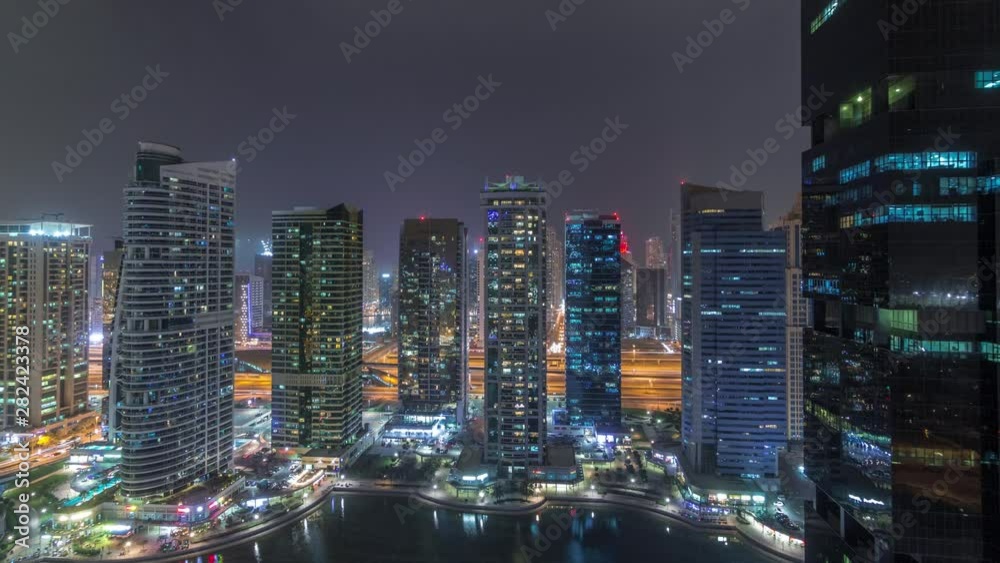 Residential and office buildings in Jumeirah lake towers district night timelapse in Dubai. Aerial panoramic view from above with modern skyscrapers Residential and office buildings in Jumeirah lake towers district night timelapse in Dubai. Aerial panoramic view from above with modern skyscrapers