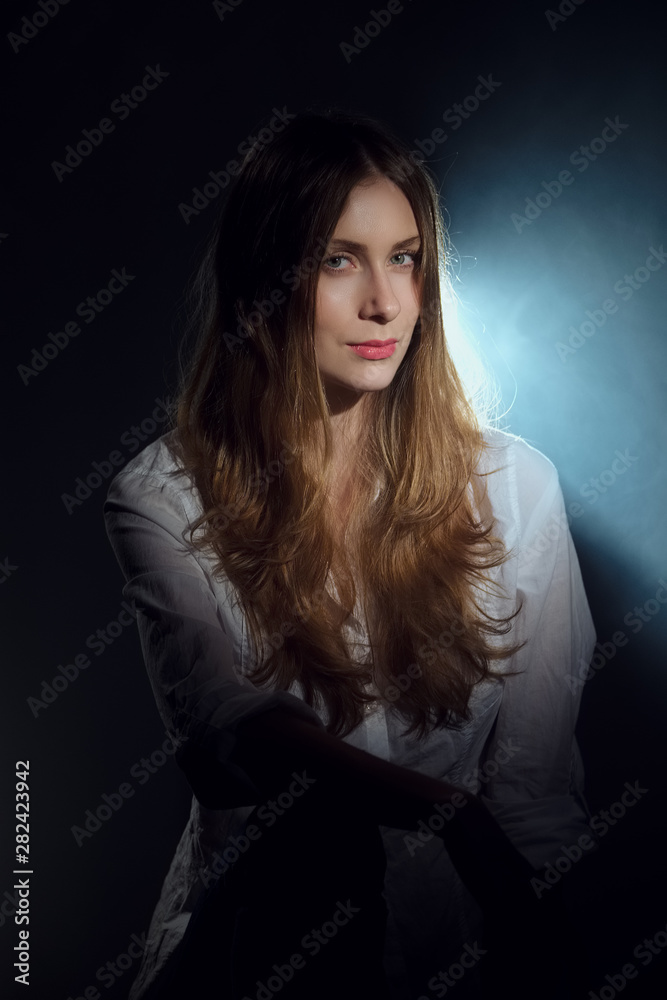 Low key portrait of beautiful girl with long curly hair