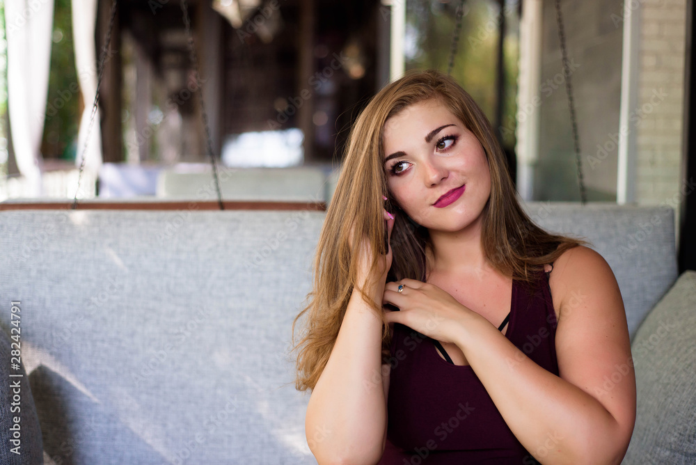Plus size beautiful young woman with tablet and phone in a restaurant. Plus size beautiful young woman with tablet and phone in a restaurant.