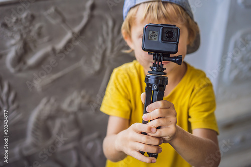 Little boy shoots a video on an action camera