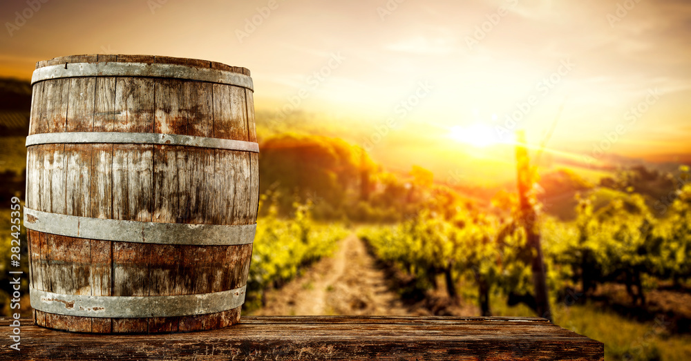 Wooden old retro barrel and autumn landscape with sunset time. Wooden old retro barrel and autumn landscape with sunset time.