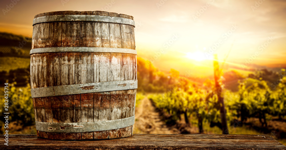Wooden old retro barrel and autumn landscape with sunset time. 