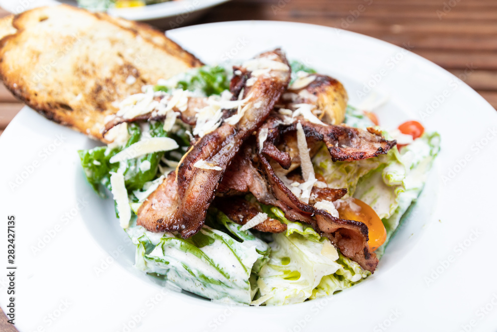 Chicken Caesar Salad. Chicken caesar salad with vegetables on plate in a cafe