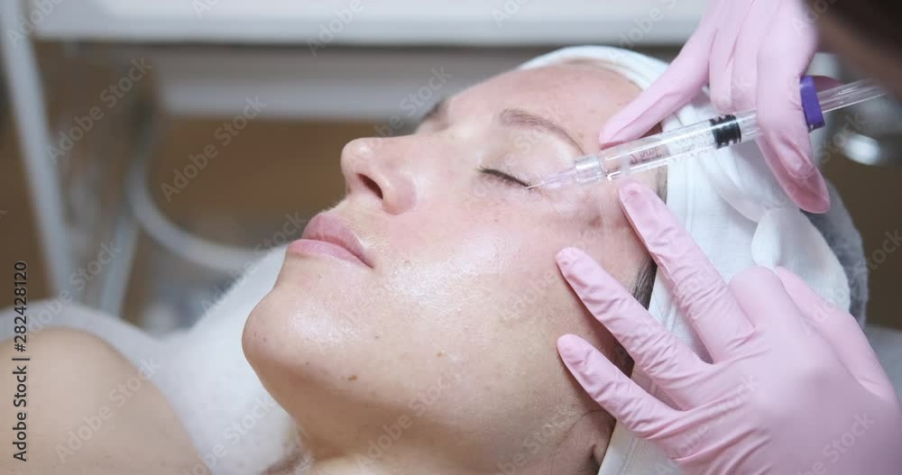 Beautiful woman getting cosmetic injection of botox in face