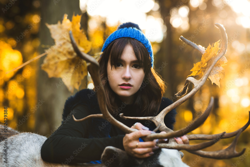 Obraz premium a beautiful girl model walking with deer in the park