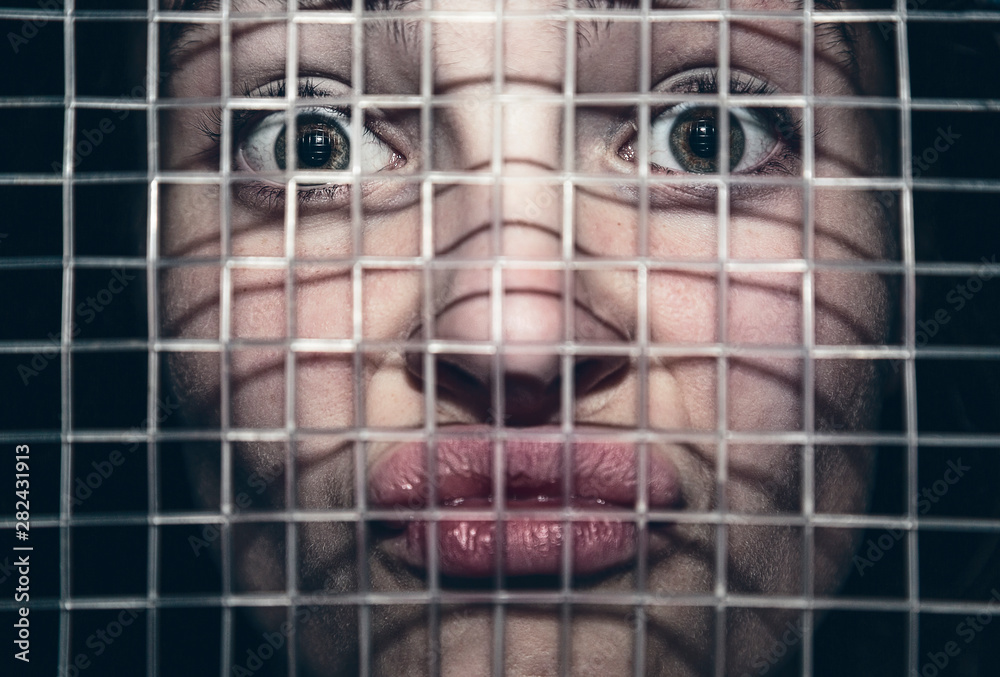 Naklejka premium Portrait of a frustrated young woman behind the lattice of a tennis racket