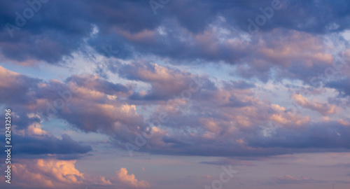 Beautiful sky at sunset: soft pink, beige and dark blue clouds 