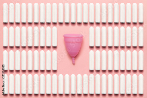 Reusable silicone menstrual cup and tampons comparison on a soft pink background. Modern female intimate alternative gynecological hygiene. Eco zero waste concept