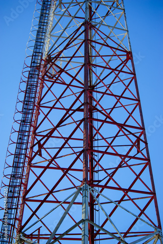 Telecommunication radio signal tower over the blue sky