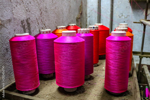 Colorful pink spools of thread for a loom await use, Varanasi, India