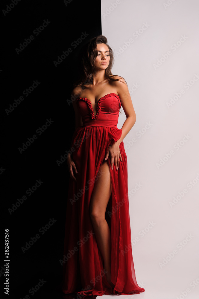 gorgeous woman in red dress. Studio picture, grey background