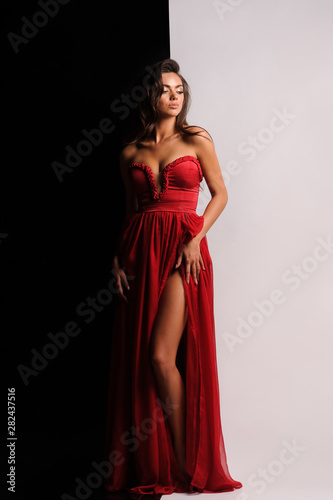 gorgeous woman in red dress. Studio picture, grey background