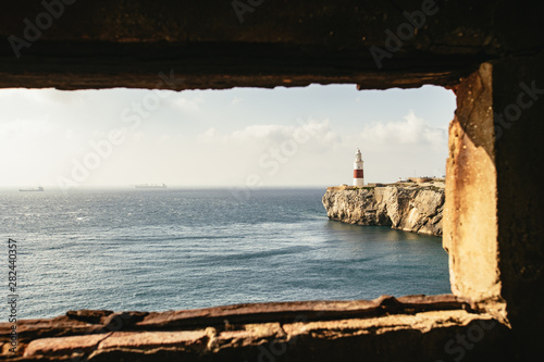 Window in foreground providing view of lighthouse