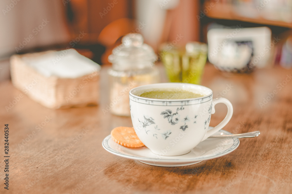 green tea matcha soy latte in a china cup with brown sugar and a glass of water on the side green tea matcha soy latte in a china cup with brown sugar and a glass of water on the side