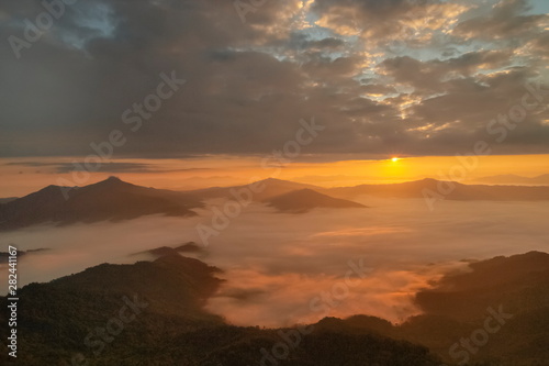 Mountain view morning of top hill around with sea of mist in valley with orange sun light and cloudy sky background  sunrise at Pha Tang  Chiang Rai  northern of Thailand.