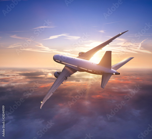 Passengers commercial airplane flying above clouds