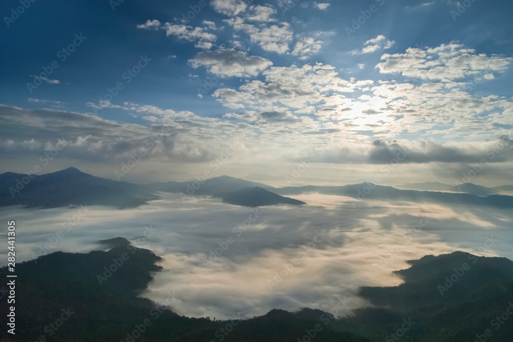 Obraz premium Mountain view morning of top hill around with sea of mist in valley with cloudy sky background, sunrise at Pha Tang, Chiang Rai, northern of Thailand.
