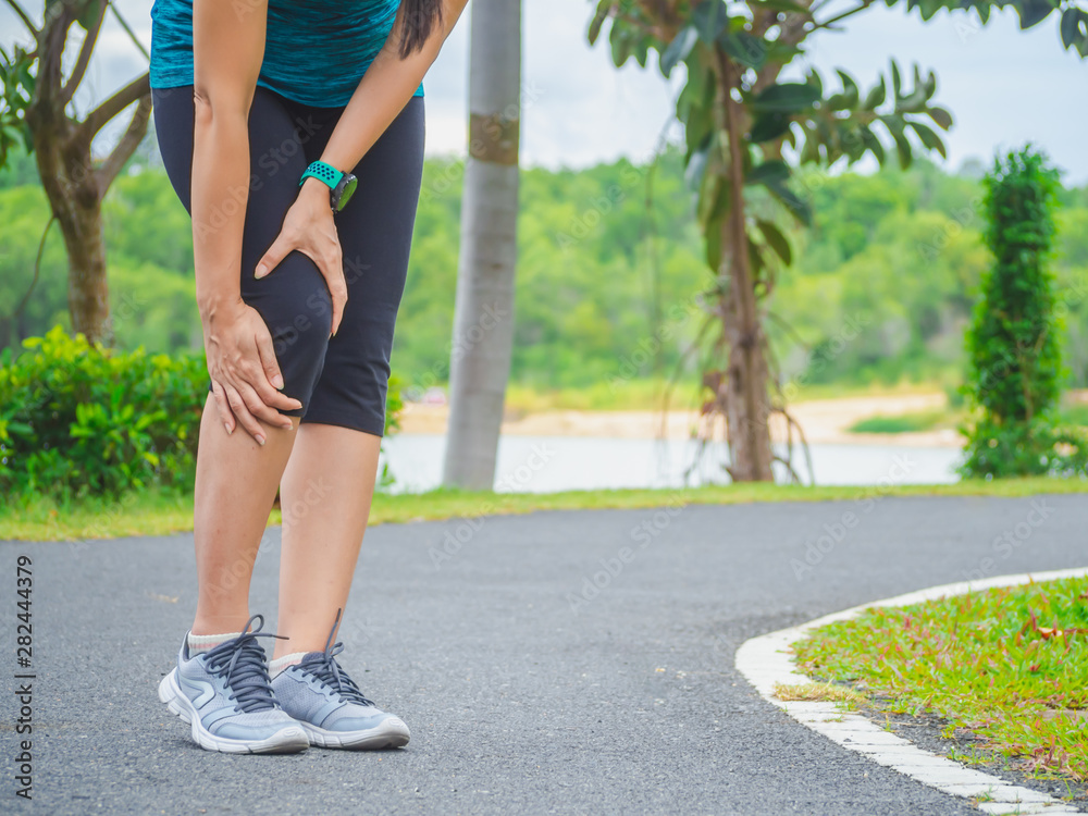 woman runner sports injured leg and knee pain at garden.
