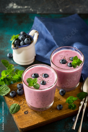Healthy Chia seed pudding in a glass with blueberry on slate table. Healthy breakfast, vitamin snack, diet and healthy eating. Free space for your text.