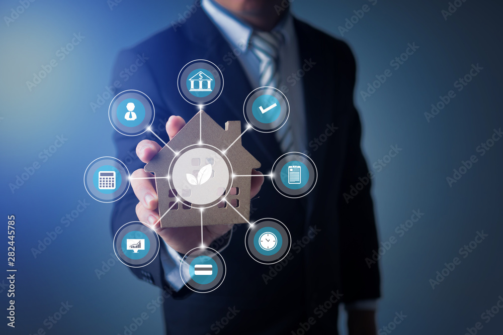 Businessman show smart home model and building with responsible for the environment and rule-based control icon, real estate concept Businessman show smart home model and building with responsible for the environment and rule-based control icon, real estate concept