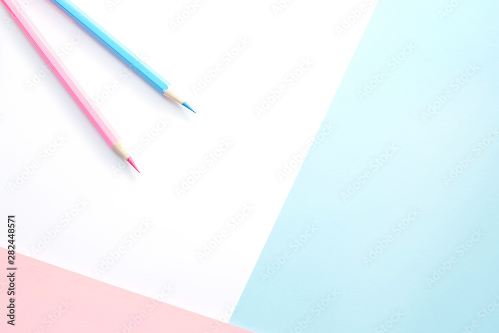 Pink and blue pencils and paper on white background. Top view, flat lay composition, frame, layout. Copy space for text or design. Pink and blue pencils and paper on white background. Top view, flat lay composition, frame, layout. Copy space for text or design.