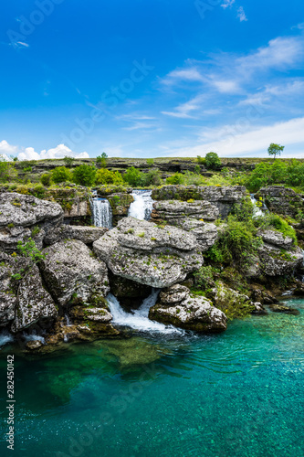Montenegro, Many small waterfalls of turquiose cijevna river water at niagara falls sight in podgorica nature scenery with blue sky