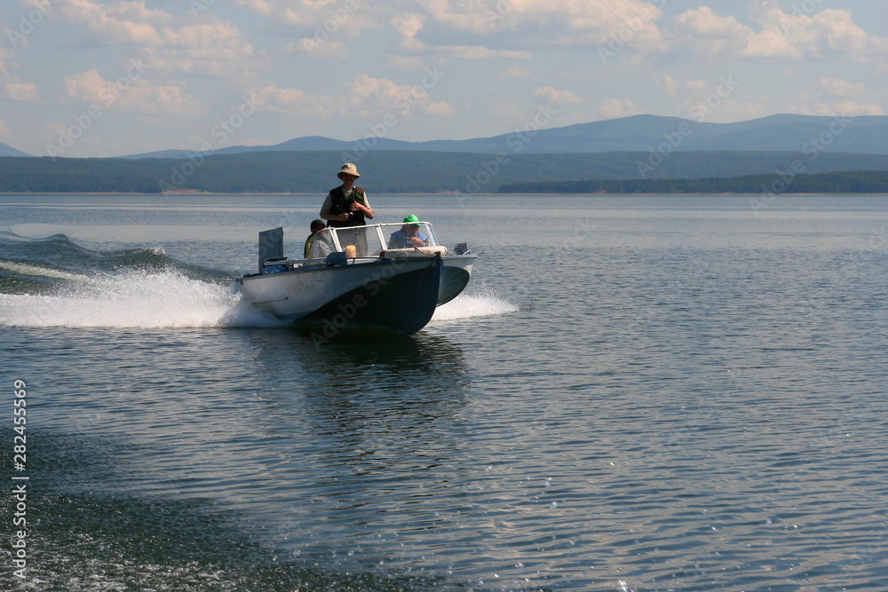 Fototapeta premium Motor boat floats quickly on the surface of the sea.