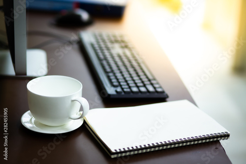 Business SME owner desk with notebook glass computer and white cup coffee at home business