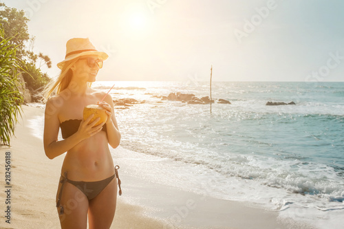 Happy Young Tourist  Smiling Caucasian Woman in hat with coconut © Andrii IURLOV