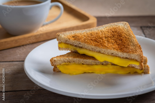 Grilled cheese sandwich on plate and coffee cup.