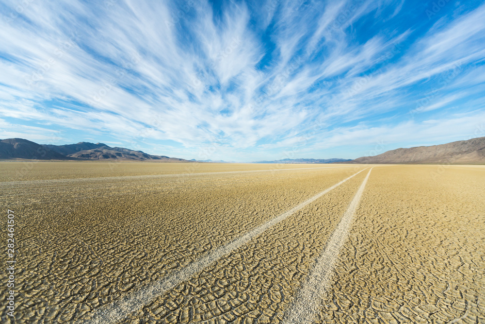 Fototapeta premium Tire tracks running across the black rock desert playa