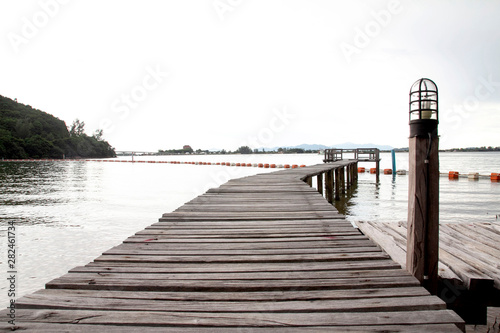 View of a wooden pier on the seashore with clear morning sky and sea