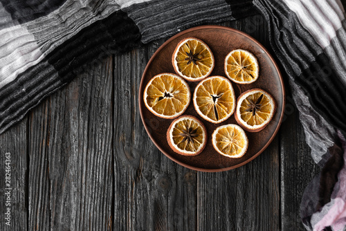 Christmas holiday, table decoration, slices of dry fragrant orange on a wooden table