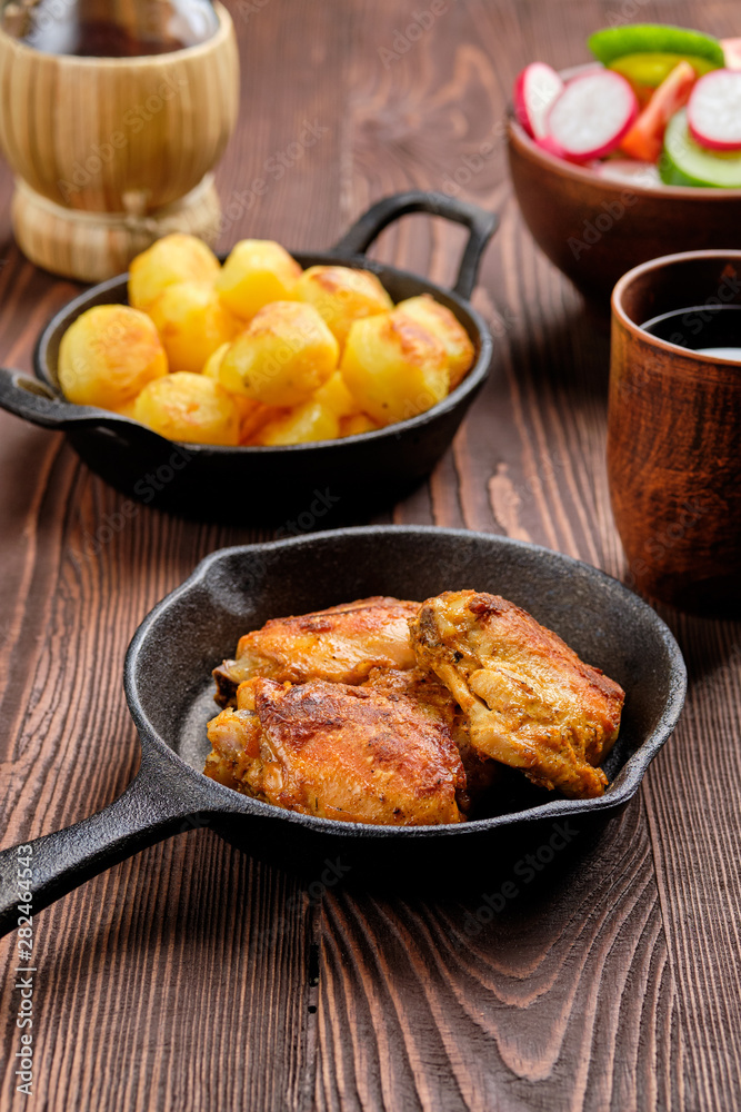 Roasted chicken thighs, fried potato and salad - rustic dinner