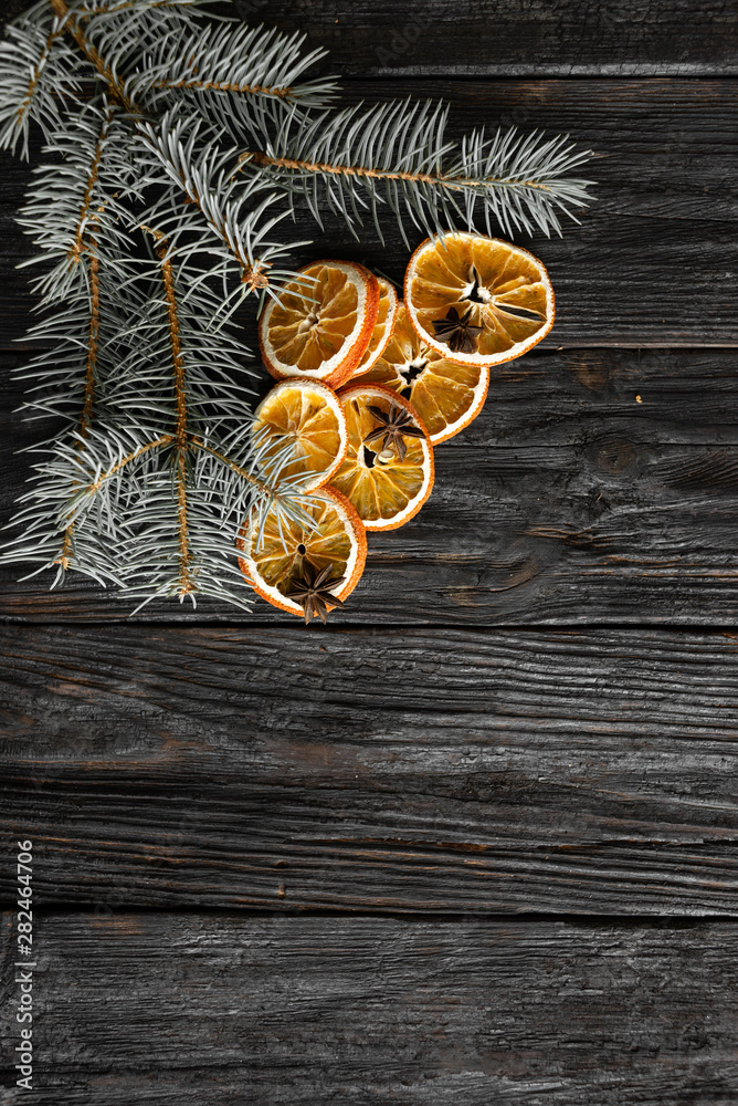 dry sliced orange with a sprig of spruce on a black board dry sliced orange with a sprig of spruce on a black board