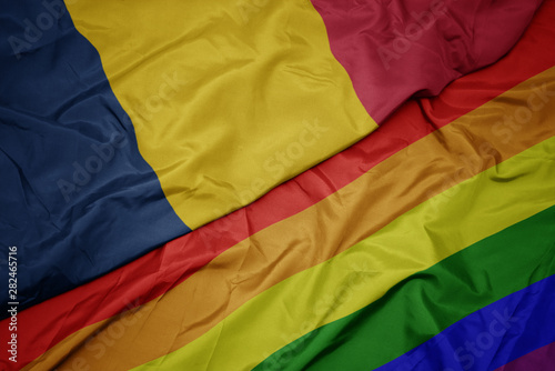 waving colorful gay rainbow flag and national flag of chad.