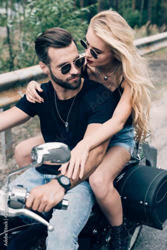 young couple of bikers closely embracing on black motorcycle © LIGHTFIELD STUDIOS