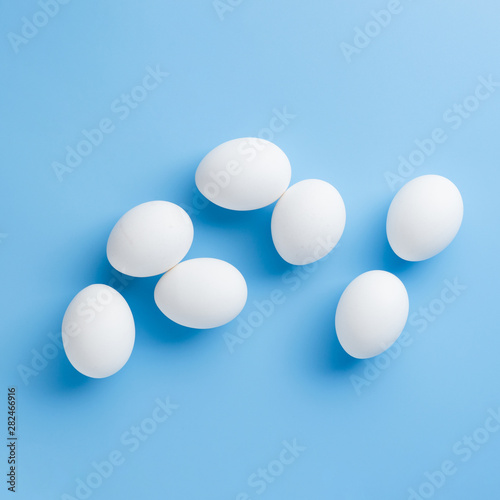 White eggs arrangement on blue background