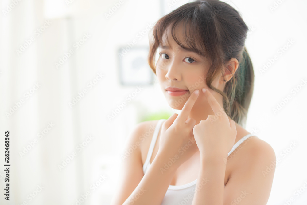 Beautiful portrait young asian woman with acne problem in the bedroom, trouble of beauty on face, zit treatment, asia girl is pimple having worry and displeased, skincare and healthy concept. Beautiful portrait young asian woman with acne problem in the bedroom, trouble of beauty on face, zit treatment, asia girl is pimple having worry and displeased, skincare and healthy concept.