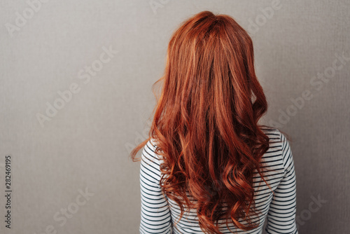 Fotografia Rear view of a woman with long curly red hair