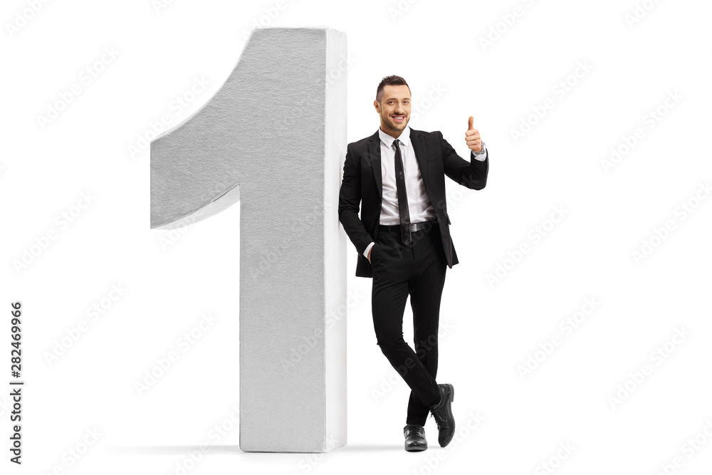 © Ljupco Smokovski - Young man in a black suit and tie leaning on number one and showing thumbs up © Ljupco Smokovski - Young man in a black suit and tie leaning on number one and showing thumbs up