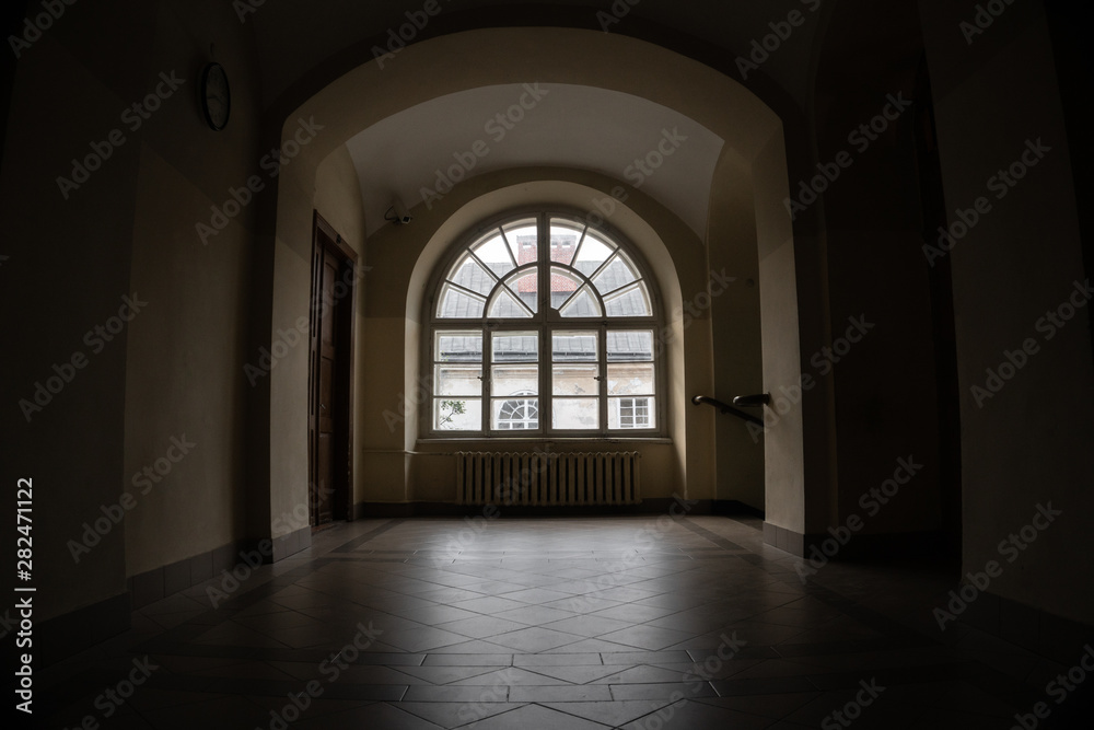 Half-round vintage window in a dark corridor of an 18th century building.