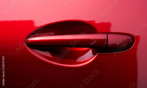 Close up of the door handle of a red car