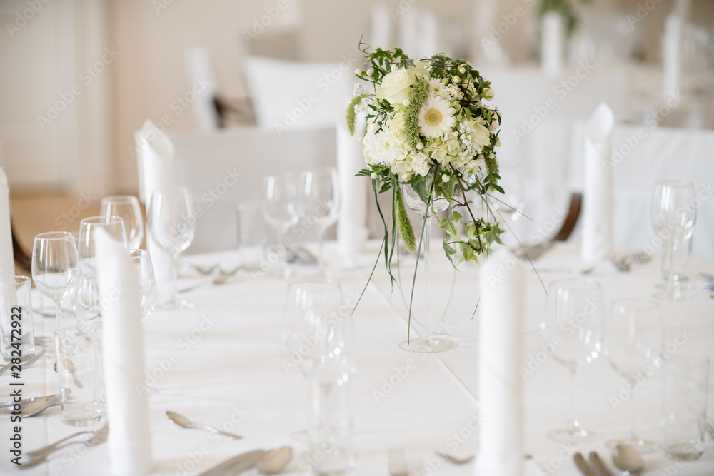 flower decoration on a laid banquet table of a wedding flower decoration on a laid banquet table of a wedding