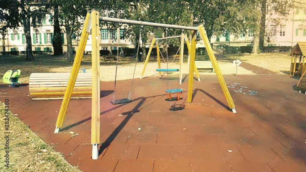 empty swings with chains swaying at playground for child, moved from wind, slow motion empty swings with chains swaying at playground for child, moved from wind, slow motion