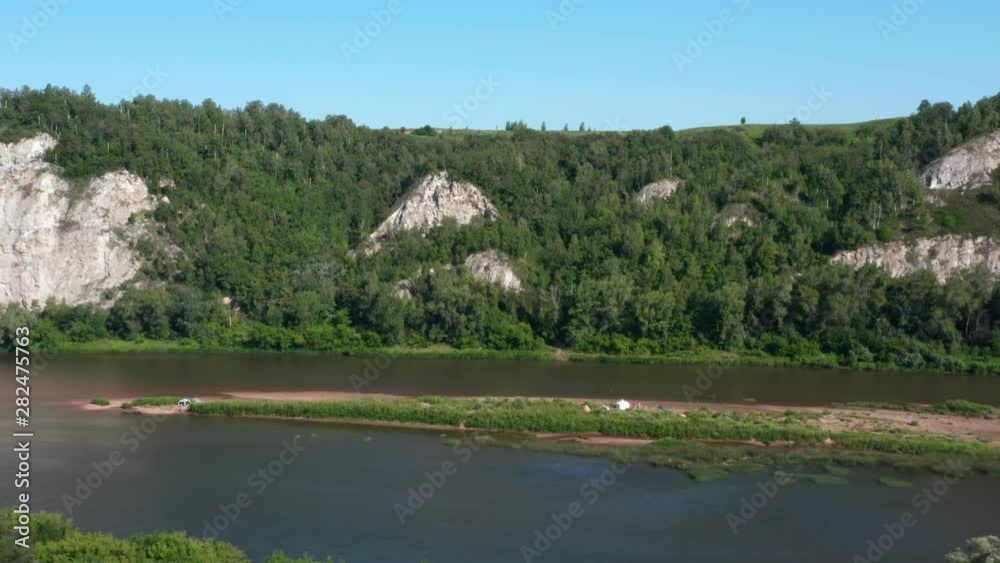 Aerial lateral shot of the river and mountains.Filming Island with tourist camps.Copter flies over on the top of the trees. Aerial lateral shot of the river and mountains.Filming Island with tourist camps.Copter flies over on the top of the trees.