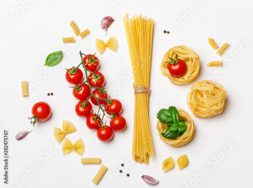 Various uncooked pasta on white background. Top view. Raw pasta with ingredients for cooking. Food concept
